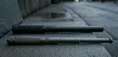 2 expandable batons lying on the ground.