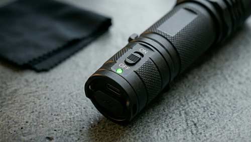 A close-up of a high-quality stun device featuring a physical safety switch in the off position