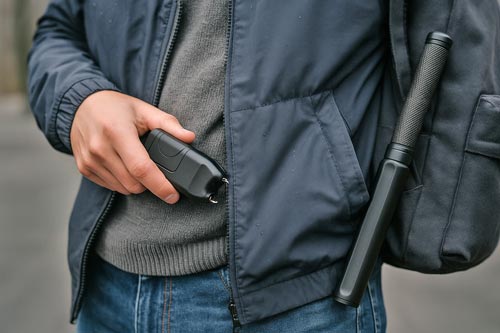 Person carrying a stun gun and a stun baton.