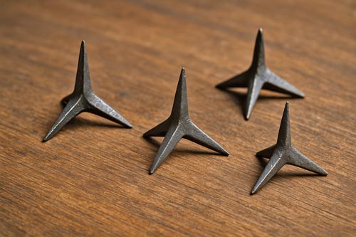 Ninja tetsubishi spikes laying on wood.