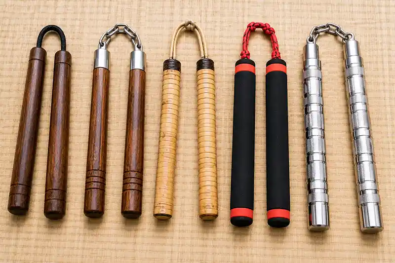 Wooden, rattan, foam, and metal nunchaku displayed side by side to show different designs and materials