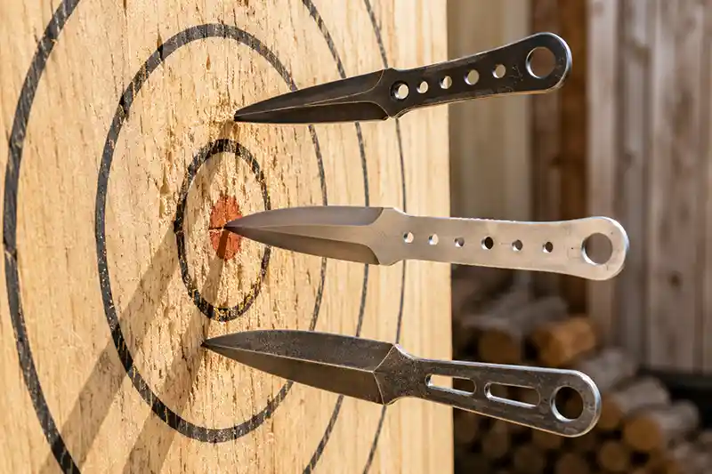Throwing knives embedded point-first in a wooden target
