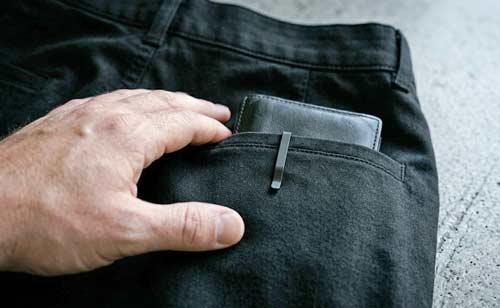 A close-up of a tactical pen clip integrated along a pants pocket seam, illustrating a subtle everyday carry method.