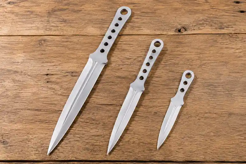 Throwing knives in three different lengths side by side