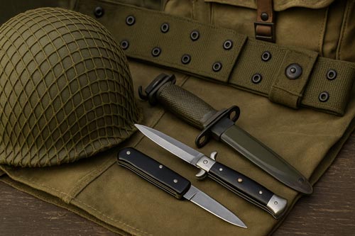 Automatic knives next to army gear.